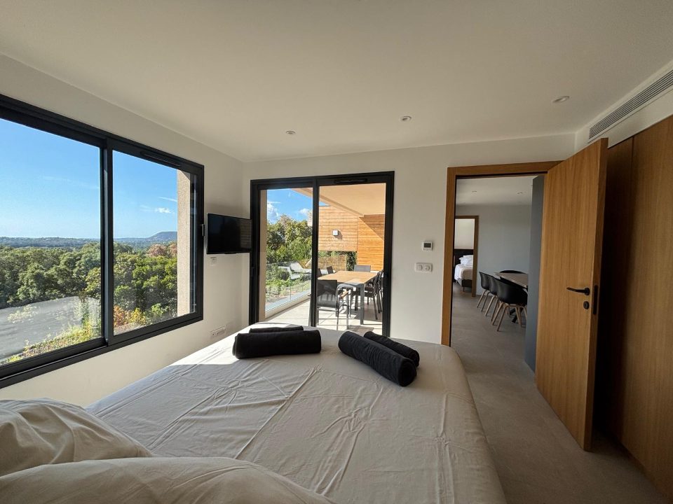 Chambre 5, suite parentale : fenêtre d’angle et accès direct à la terrasse.